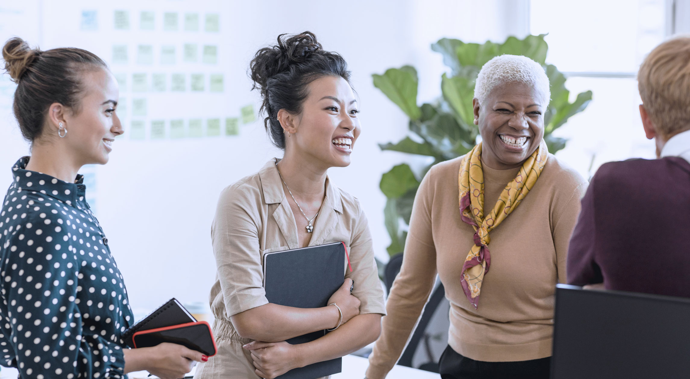 Група усмихнати колеги обсъждат идеи в неформална обстановка, създавайки приятелска и позитивна атмосфера