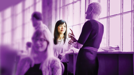 Колеги в оживена дискусия в офис среда, споделящи идеи и сътрудничество около работна маса.