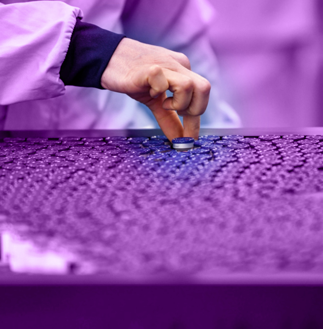 Ръка на техник проверява запечатана стъклена бутилка в производствена линия, демонстрирайки контрол на качеството.